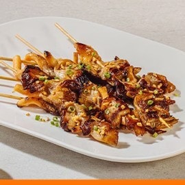 King oyster mushroom inasal on a white plate.   King oyster mushroom inasal on a white plate.