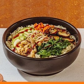 Cauliflower bibimbap in a black stone bowl with gochujang on the side. Cauliflower bibimbap in a black stone bowl with gochujang on the side.