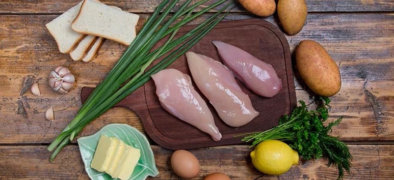 Various raw ingredients, including chicken breast, cheese, eggs, and vegetables Various raw ingredients, including chicken breast, cheese, eggs, and vegetables