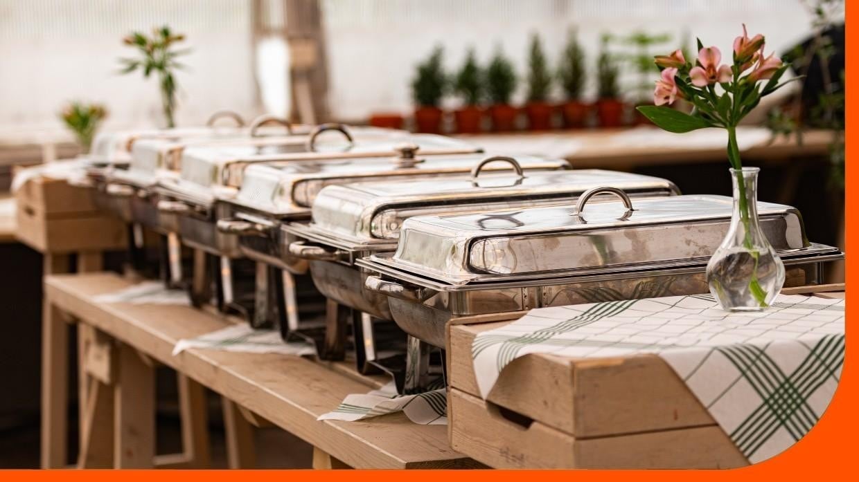 A buffet table with covered chafing dishes ready for service. A buffet table with covered chafing dishes ready for service.